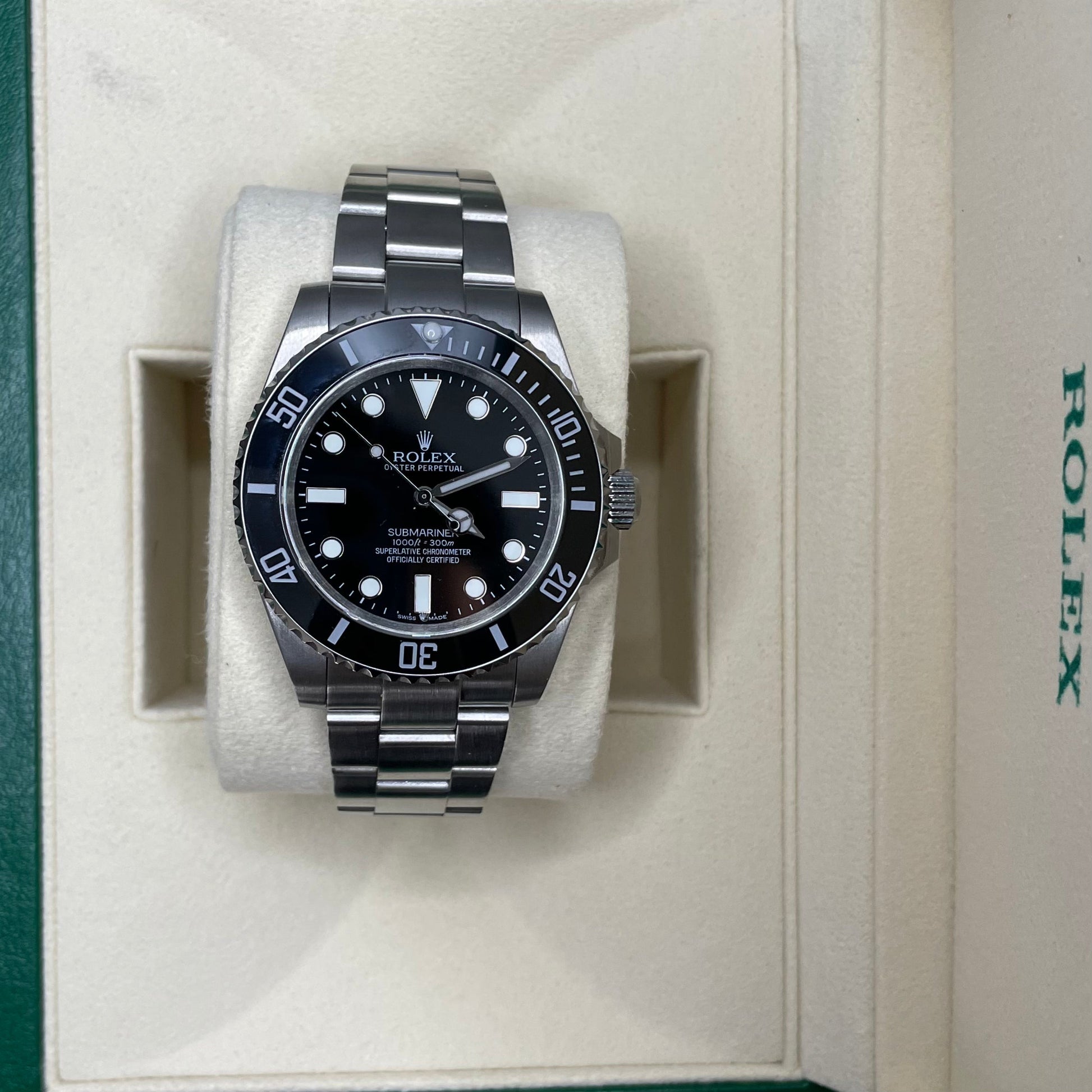 Orologio Rolex Replica Submariner con quadrante nero e cinturino in acciaio inox, esposto in una scatola con il logo rolex 