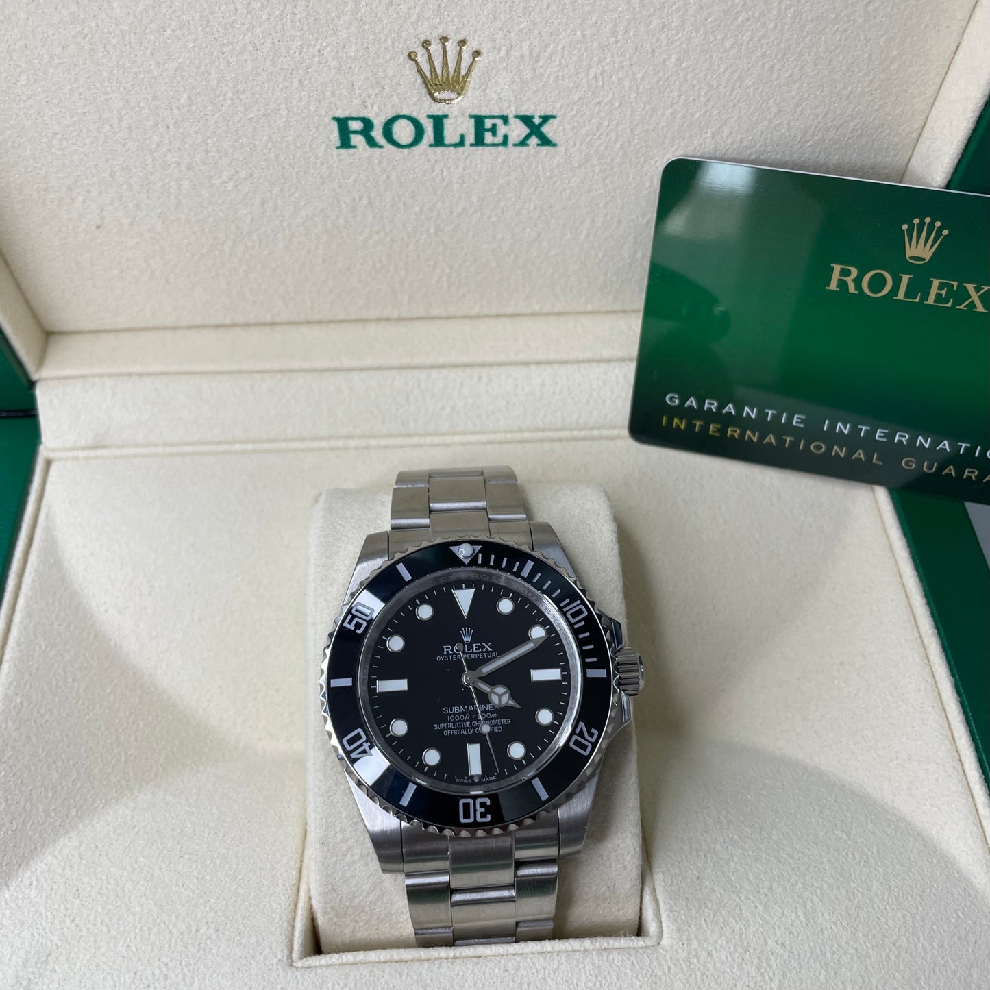 Orologio Rolex Replica Submariner con quadrante nero e cinturino in acciaio inox, esposto in una scatola con il logo rolex 